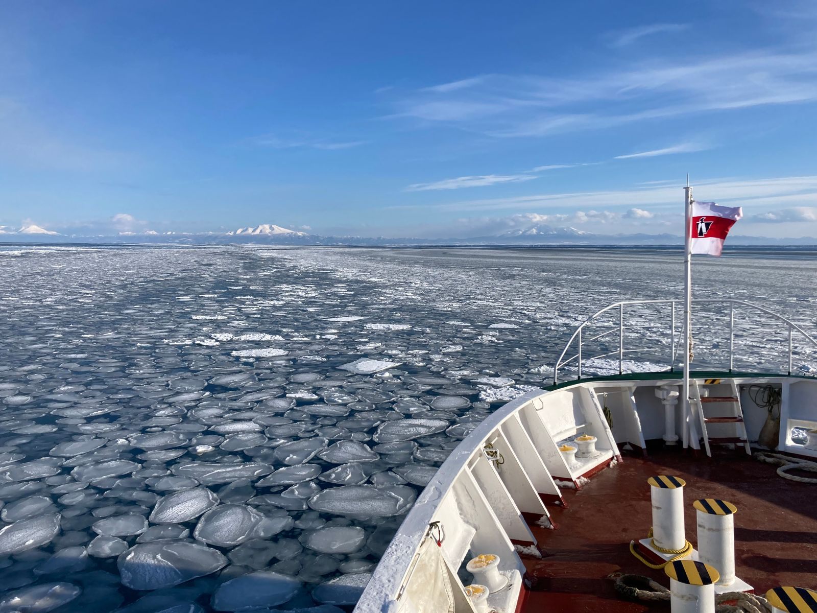 View from the bow of an expedition cruise ship pushing through sea ice